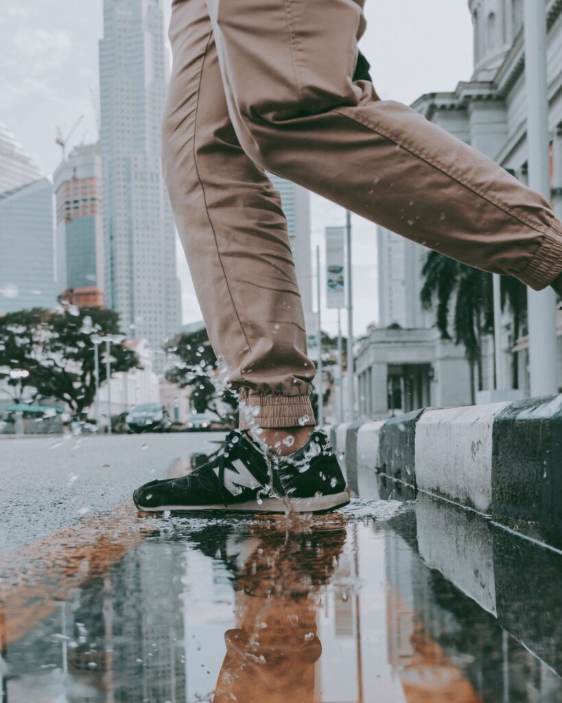 Man in Sneakers jumps, splashes into puddle