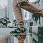 Man in Sneakers jumps, splashes into puddle